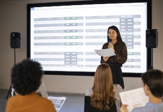 Image of speaker standing in front of screen for Audio Visual information